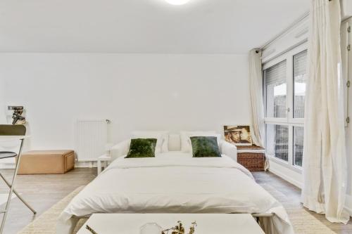 2 Betten in einem weißen Zimmer mit Fenster in der Unterkunft Chic studio Appartment in Rosny-sous-Bois