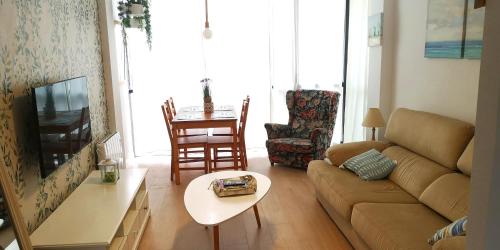 ein Wohnzimmer mit einem Sofa und einem Tisch in der Unterkunft Somo Playa Vistas in Somo