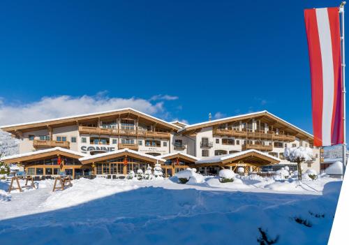 a large lodge in the snow with snow at Hotel & Spa Sonne 4 Sterne Superior in Kirchberg in Tirol