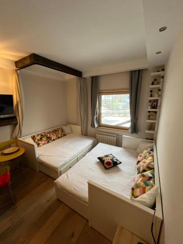 two beds in a small room with a window at Apartman Brvenik 103, Konaci, Kopaonik in Kopaonik