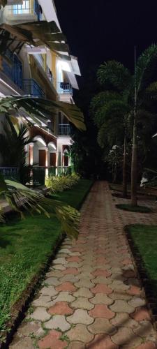 a cobblestone path in front of a building at night at Passions de Goa in Anjuna