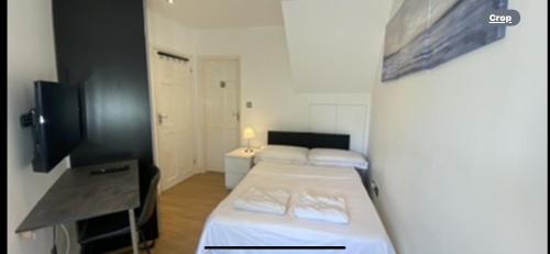 Zimmer mit 2 Betten und einem TV. in der Unterkunft Lovely one bedroom flat in Hendon in The Hyde