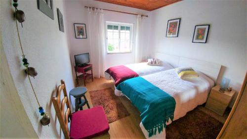 a bedroom with a bed and a chair and a window at Quinta do Sol in Alijó