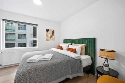a bedroom with a bed with two towels on it at Unwind in Luxury Steps From Smáralind Mall in Reykjavík