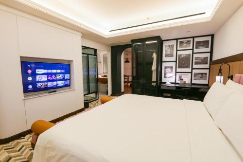 a bedroom with a bed and a flat screen tv at Java Paragon Hotel & Residences in Surabaya