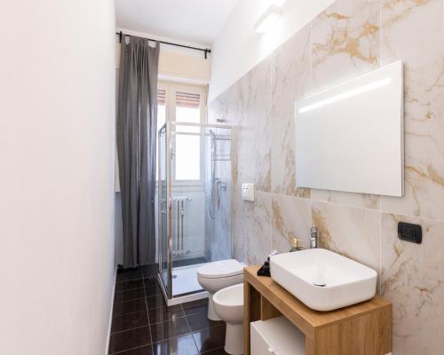 uma casa de banho com um WC, um lavatório e um espelho. em Edolo#28 - Vicino Metro e Stazione Centrale em Milão
