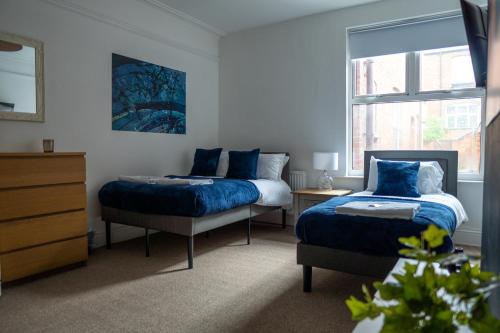 a bedroom with two beds and a dresser at Central 6Bed Retreat - Your Perfect Coventry Holiday Home Away in Coventry