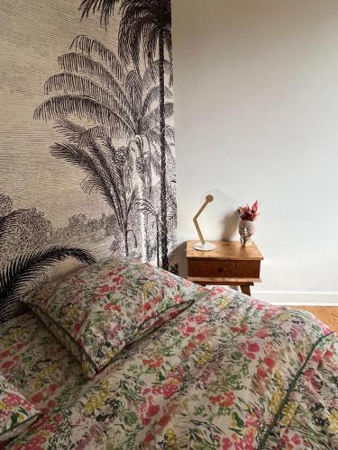 um quarto com uma cama com papel de parede tropical em Chambre confortable chez particulier avec salle de bain privée em Nantes