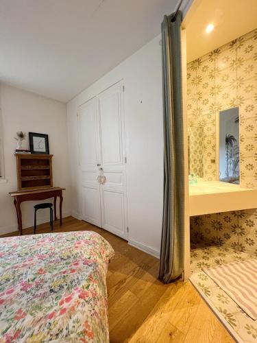 a bedroom with a bed and a desk and a mirror at Chambre confortable chez particulier avec salle de bain privée in Nantes
