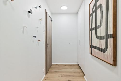a hallway with a door and paintings on the wall at Unwind in Luxury Steps From Smáralind Mall in Reykjavík