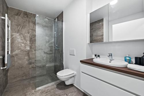 a bathroom with a toilet and a sink and a shower at Venture Vacations - Unwind in Luxury Steps From Smáralind Mall in Reykjavík