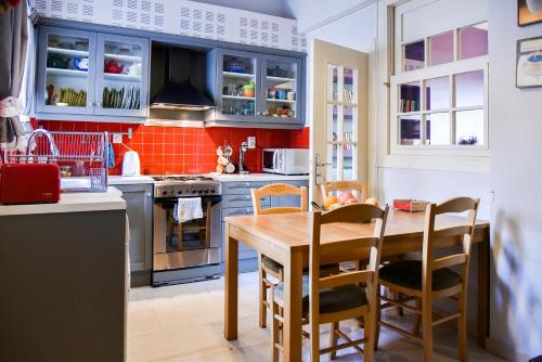 eine Küche mit blauen Schränken und einem Holztisch in der Unterkunft Colourful Apt in Nea Smyrni in Athen