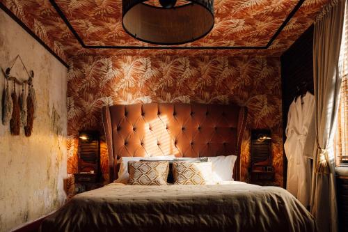 um quarto com uma cama grande e uma grande cabeceira. em The George & Heart House em Kent