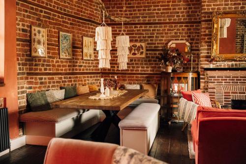 a dining room with a table and a brick wall at The George & Heart House in Kent