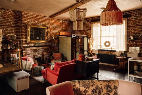 a living room with a red couch and a brick wall at The George & Heart House in Kent