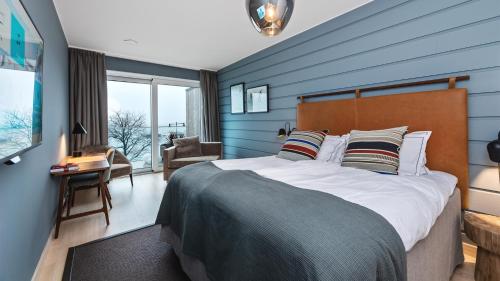 1 dormitorio con 1 cama grande y pared azul en Slottsholmen Hotell och Restaurang en Västervik