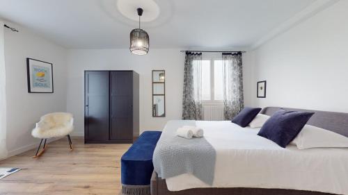 une chambre avec un grand lit et une chaise dans l'établissement Appartement PLEIN-CIEL, à Villeurbanne