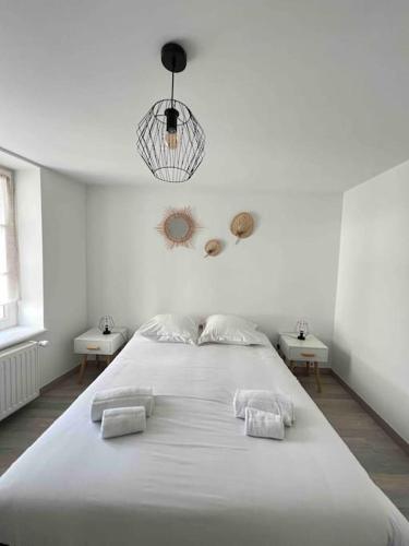 - une chambre blanche avec un grand lit blanc et 2 serviettes dans l'établissement Le Brèche, appartement spacieux, Orléans Sud, à Orléans