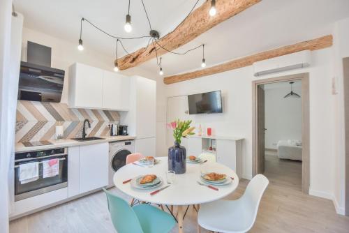 a kitchen and dining room with a white table and chairs at LE PETIT CASTELET - New superb flat in old Antibes, AC, WIFI, for 4 in Antibes
