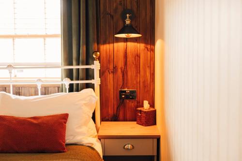 a bedroom with a bed and a window and a lamp at The George & Heart House in Kent