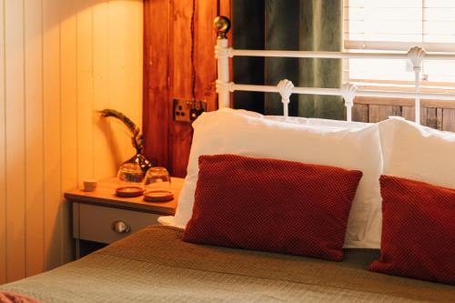a bedroom with a bed with two red and white pillows at The George & Heart House in Kent