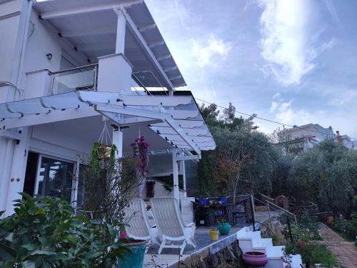 a white pergola on the side of a house at Villa Panorama, now a Smart Home in Skala Kallirakhis