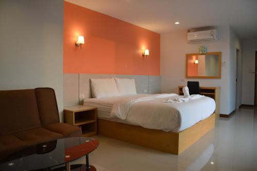 um quarto de hotel com uma cama e uma cadeira em The Base Hua Hin em Hua Hin