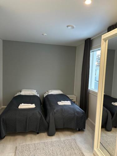 1 dormitorio con 2 camas y espejo en Kotimaailma Apartments #1 - Loistava kaksio keskustassa en Seinäjoki