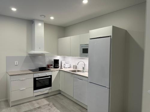uma cozinha com armários brancos e um frigorífico em Kotimaailma Apartments #1 - Loistava kaksio keskustassa em Seinäjoki