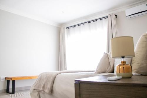a bedroom with a bed and a large window at Asania Guest House in Bloemfontein
