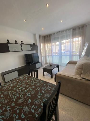 Un dormitorio con una cama, un sofá y un televisor. en Apartamento VISTA MAR, en Salou