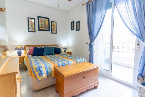 um quarto com uma cama, uma secretária e uma janela em rentafive Nuevo AA Admite Perros Barbacoa em Santa Pola
