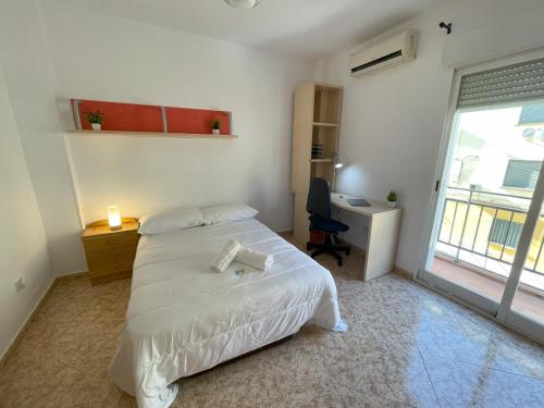 a bedroom with a bed and a desk and a window at Piso compartido Delyrent, Safa in Jaén