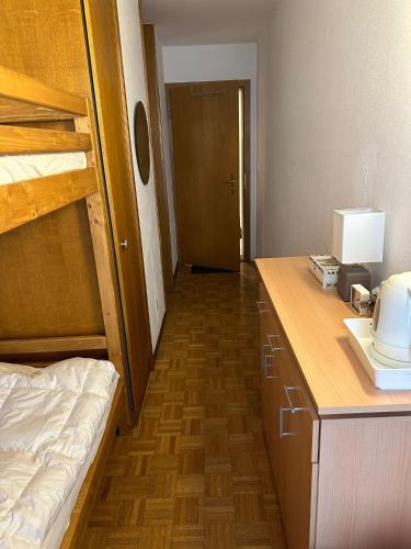 een slaapkamer met een stapelbed en een bureau met een telefoon bij Chambre Indépendante Valdor in Crans-Montana