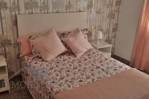 Un dormitorio con una cama con almohadas encima. en Ático del sol, en Fuengirola