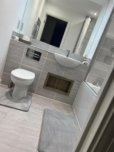 a bathroom with a white toilet and a sink at Stylish Luxury new 2 bedroom Apartment in Dartford