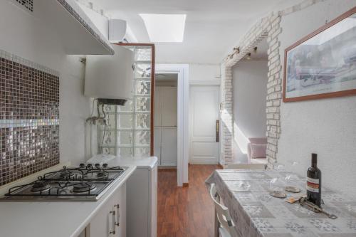 uma cozinha branca com um fogão e um lavatório em Loft Rossetti em Trieste