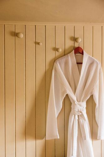 a white dress on a hanger on a wall at The George & Heart House in Kent