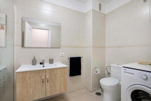a bathroom with a sink and a toilet and a mirror at El Pisito de Momo in Candelaria
