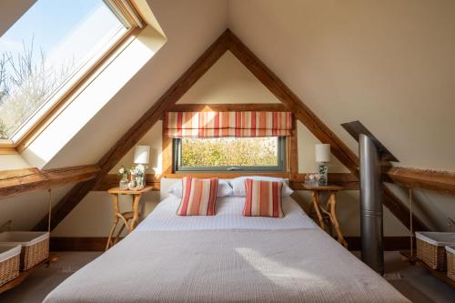 um quarto com uma cama num sótão em The Nook em Holbeton