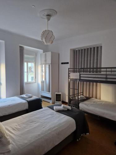 sypialnia z 2 łóżkami piętrowymi i żyrandolem w obiekcie Zuni Guest House w Lizbonie