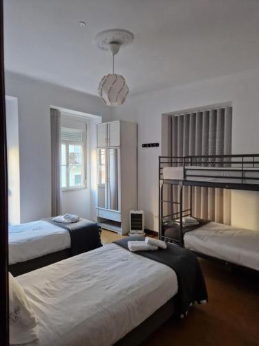sypialnia z 2 łóżkami piętrowymi i żyrandolem w obiekcie Zuni Guest House w Lizbonie