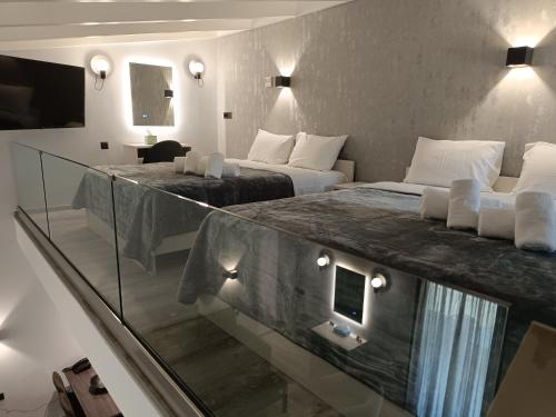 pokój hotelowy z 2 łóżkami i szklaną ścianą w obiekcie Oikos 9 Rooms and Suites w mieście Nafpaktos