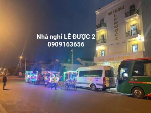 un groupe de camionnettes garées devant un bâtiment la nuit dans l'établissement NHÀ NGHỈ LÊ ĐƯỢC 2, à Hà Tiên