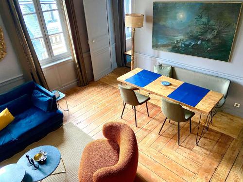 een woonkamer met een houten tafel en stoelen bij Duplex LE GLENCOE in Honfleur