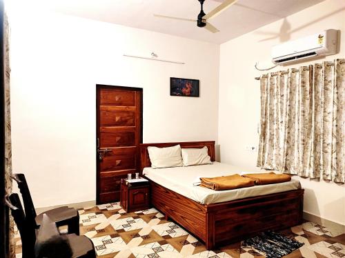ein Schlafzimmer mit einem Bett und einem Stuhl darin in der Unterkunft Suncrest Wood Stayz in Alibag