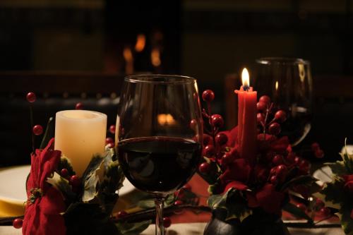 a table with a glass of wine and a candle at Le Cedrus Hotel in Al Arz