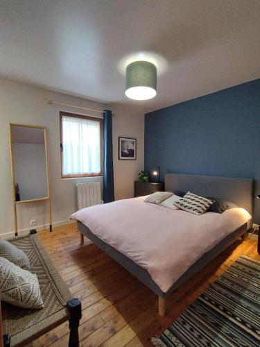 1 dormitorio con 1 cama grande y pared azul en Chalet de la Cianario, en Valdeblore