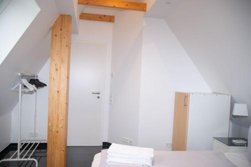 a bedroom with white walls and a bed with white sheets at SüdWind, Haus Portscher in Norderney