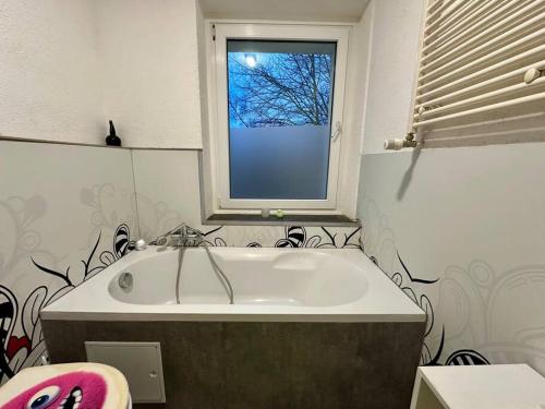 a bathroom with a bath tub and a window at An der Linde in Kall
